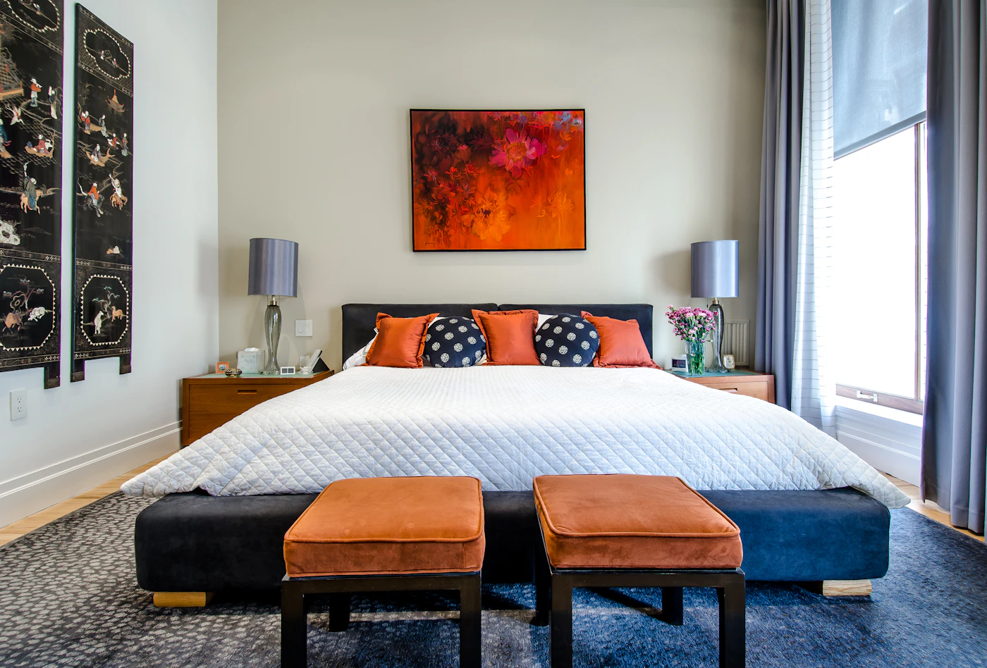 Soft evening light over a tidy bed with linen sheets
